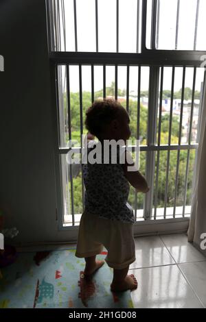 salvador, bahia / brazil - april 4, 2017: child is seen next to the apartment window grille in the city of Salvador. *** Local Caption *** Stock Photo