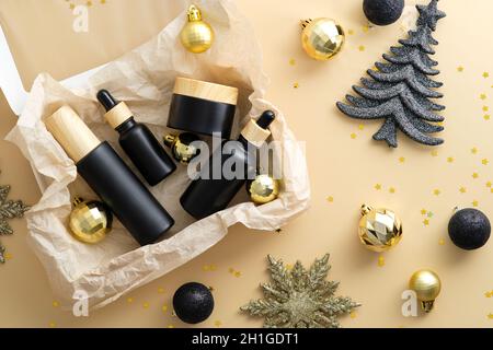 Subscription box with beauty products and Christmas decorations on beige background, Stock Photo