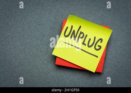 unplug  - lifestyle, information overload or digital minimalism concept  - handwriting on a sticky note Stock Photo