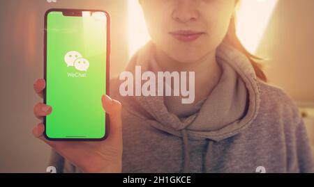 KYIV, UKRAINE-JANUARY, 2020: Wechat on Smartphone Screen. Young Girl Showing Smart Phone Screen with Wechat on it while Looking at the Camera. Focus o Stock Photo