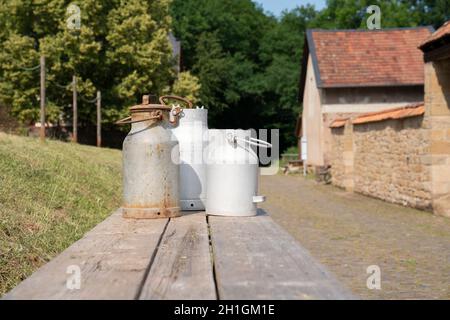 BAD SOBERNHEIM, GERMANY - JUNE 26, 2020: Old milk churns on a bench, village outdoor museum in Bad Sobernheim on June 26, 2020 in Germany Stock Photo