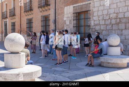 Valladolid, Spain - July 18th, 2020: A group of unknown tourists with a professional tourist guide visiting the old city of Valladolid. They are weari Stock Photo