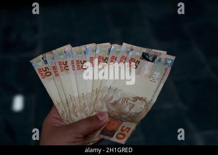 Premium Photo  Brazillian money, man holding 50 reais notes