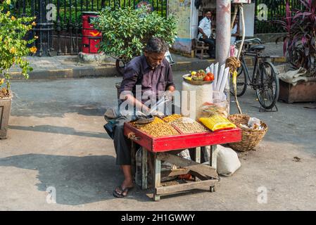 Mumbai, India - November 22, 2019: Indian man selling nuts at a street market in Mumbai (colloquially known as Bombay), India. Stock Photo
