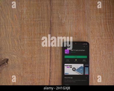 Lod, Israel - July 8, 2020: PAY app play store page on the display of a black mobile smartphone on wooden background. Top view flat lay with copy spac Stock Photo