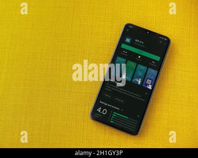 Lod, Israel - July 8, 2020: Bit app play store page on the display of a black mobile smartphone on a yellow fabric background. Top view flat lay with Stock Photo