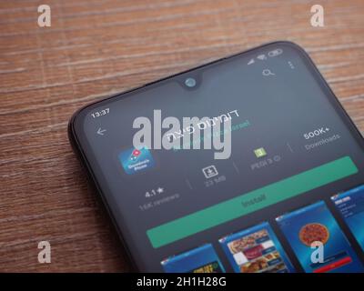 Lod, Israel - July 8, 2020: Domino's Pizza Israel app play store page on the display of a black mobile smartphone on wooden background. Top view flat Stock Photo
