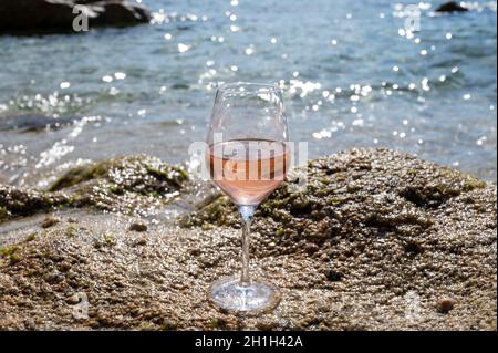 Summer time in Provence, glass of cold rose wine on sandy beach near Saint-Tropez in sunny day, Var department, France