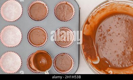 Step by step. Scooping batter with batter scooper into cupcake pan lined  with paper cupcake liners Stock Photo - Alamy