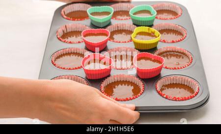 cupcake paper molds filled with dough ready to put in the oven
