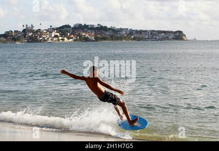 salvador, bahia / brazil - august 12, 2015: young man is seen surfing with a piece of wood on Ribeira beach in the city of Salvador. *** Local Caption Stock Photo