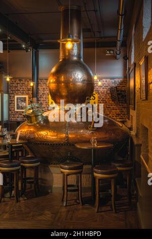 Bushmills, Northern Ireland, Aug 2019 Large, copper fermentation vat in Bushmills whiskey bar as decoration, distillery visitor centre and shop Stock Photo