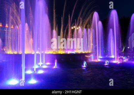 Jets of a night multi-colored illuminated fountain close-up Stock Photo