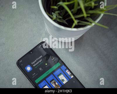Lod, Israel - July 8, 2020: Modern minimalist office workspace with black mobile smartphone with Signal Private Messenger app play store page on marbl Stock Photo