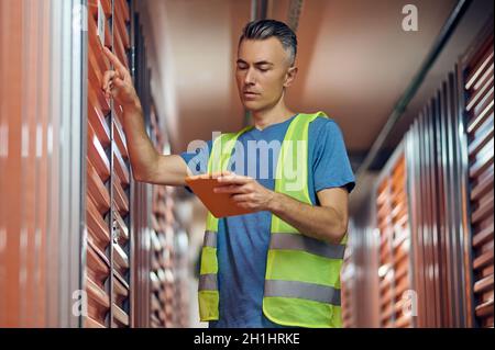 Attentive man with tablet checking data Stock Photo