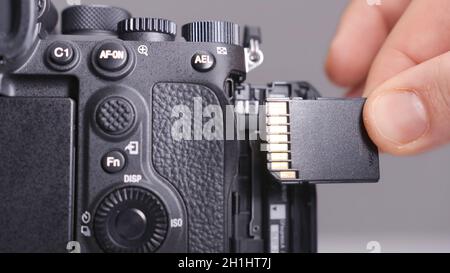 RUSSIA, MOSCOW-DECEMBER, 2020: Memory card in camera. Action. Close-up photographer inserts new memory card into camera. Replacing memory card in came Stock Photo