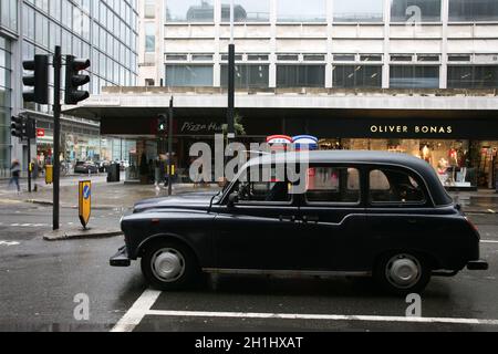 London, UK - February 26, 2011: Taxi in the street of London. Black cabs are the most iconic symbol of London as well as London's Red Double Decker Bu Stock Photo