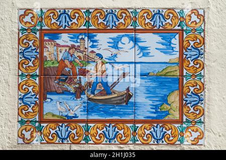 BARCELONA, SPAIN - JUNE 2, 2013: Picture of a mosaic depicting the fisher in Spain. An image of specially painted tiles and pieces of glaze on the wal Stock Photo