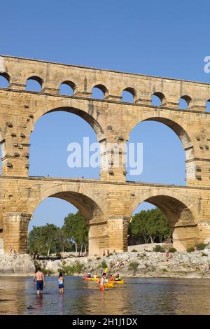 NIMES, FRANCE - August 18, 2012: People near the famous landmark ancient old double arches of Roman aqueduct of Pont du Gard, Nimes, France Stock Photo