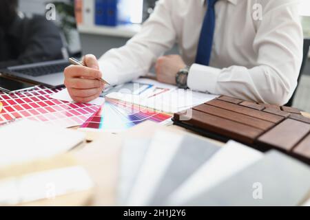 A male designer chooses a color from a palette Stock Photo