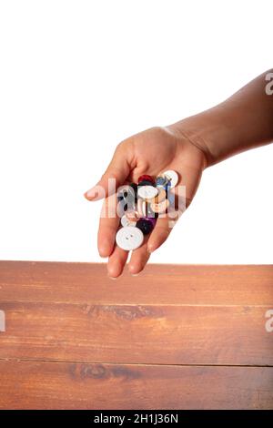 Hand full of clothes buttons. Hand isolated on white background. Stock Photo