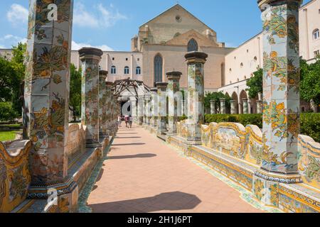 NAPLES, ITALY - AUGUST 1, 2018: Sunny cloister of the Clarisses decorated with majolica tiles from Santa Chiara Monastery in Naples, Italy. Stock Photo