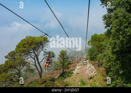 CAPRI, ITALY - July 29, 2018: Tourists riding up the mountain lift. Capri is a popular tourist destination and an island of Italy. Stock Photo
