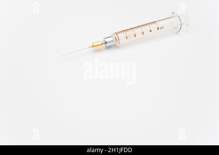 isolated sterilized glass injection syringe on a white surface Stock Photo