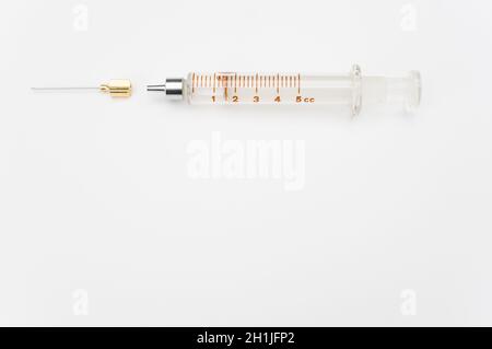 isolated sterilized glass injection syringe on a white surface Stock Photo