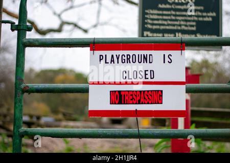 A Sign in Response to COVID-19 That Says the Playground is Closed and No Trespassing Stock Photo