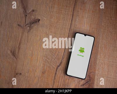 Lod, Israel - July 8, 2020: Duolingo - Language learning app launch screen with logo on the display of a black mobile smartphone on wooden background. Stock Photo