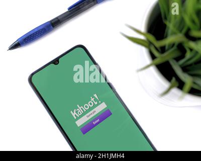 Lod, Israel - July 8, 2020: Modern minimalist office workspace with black mobile smartphone with Kahoot! app launch screen with logo on a white backgr Stock Photo