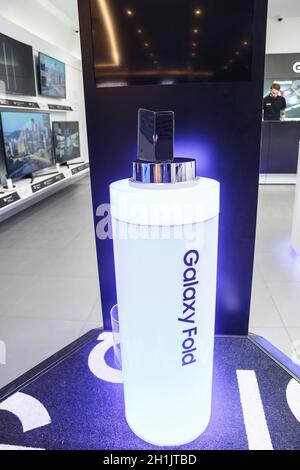 Minsk, Belarus - December 25, 2019: Viewing the new Samsung Galaxy Fold 5G. Folding touch screen smartphone on presentation stand in the window of the Stock Photo