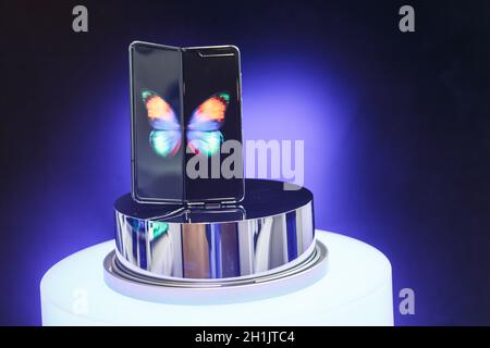 Minsk, Belarus - December 25, 2019: Viewing the new Samsung Galaxy Fold 5G. Folding touch screen smartphone on presentation stand in the showcase of t Stock Photo