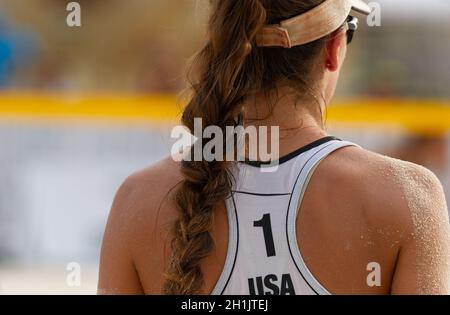 A Female Beach Volleyball Player Is Getting Ready To Serve The Ball Stock Photo