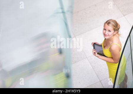 Pretty, young woman using a tablet computer in corporate context Stock Photo