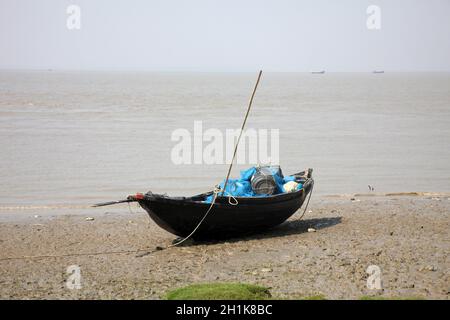 Boats of fishermen stranded in the mud at low tide on the coast of Bay of Bengal, India Stock Photo