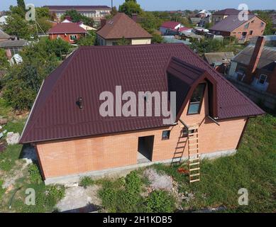 The roof of corrugated sheet. Roofing of metal profile wavy shape. House with a new metal roof. Stock Photo