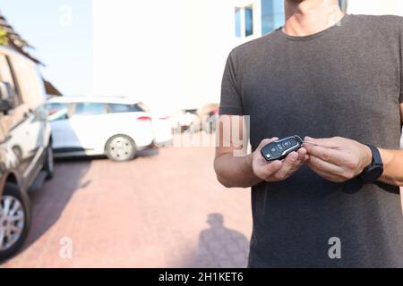 Man holds in hands push-button remote control from car closeup Stock Photo