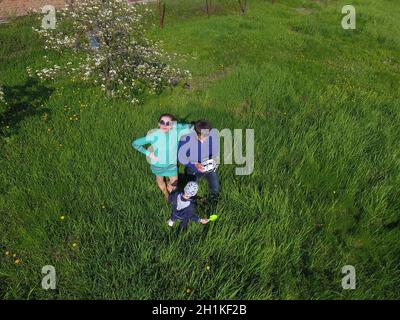 A man and a woman are photographed from a drone on a green clearing Stock Photo