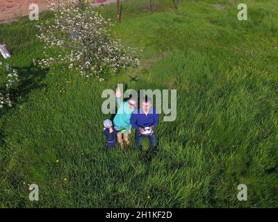 A man and a woman are photographed from a drone on a green clearing Stock Photo