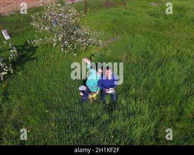 A man and a woman are photographed from a drone on a green clearing Stock Photo