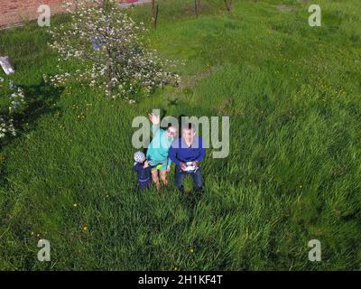 A man and a woman are photographed from a drone on a green clearing Stock Photo