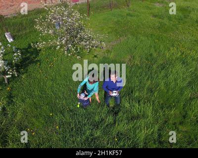 A man and a woman are photographed from a drone on a green clearing Stock Photo