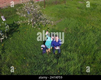 A man and a woman are photographed from a drone on a green clearing Stock Photo