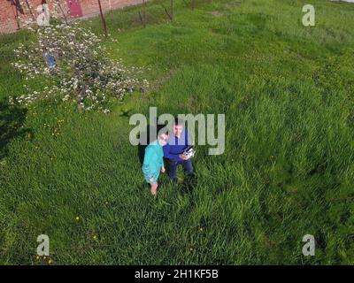 A man and a woman are photographed from a drone on a green clearing Stock Photo