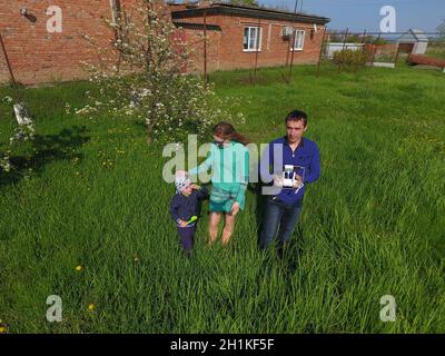 A man and a woman are photographed from a drone on a green clearing Stock Photo