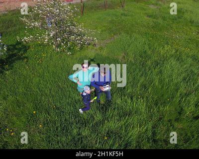 A man and a woman are photographed from a drone on a green clearing Stock Photo