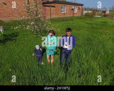 A man and a woman are photographed from a drone on a green clearing Stock Photo