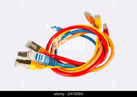 Multi-colored cables for a computer network twisted together. Isolated over. Red blue yellow and orange. Stock Photo